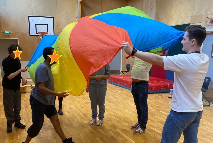 en gruppe mennesker som holder et stort fargerikt flagg