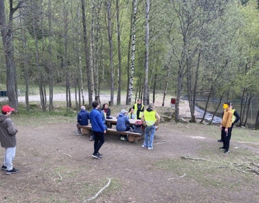 en gruppe mennesker som sitter på en benk i en skog