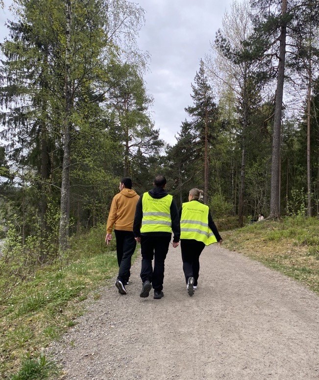 En gruppe mennesker som går på en sti i skogen