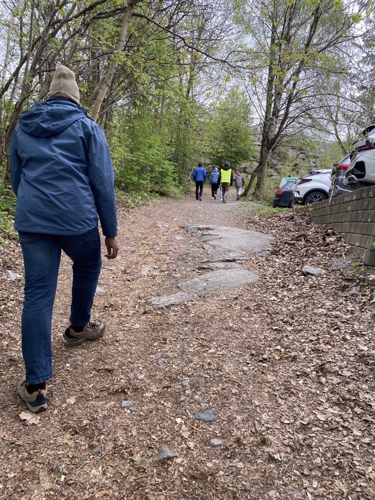 en person som går på en sti med folk som går på siden