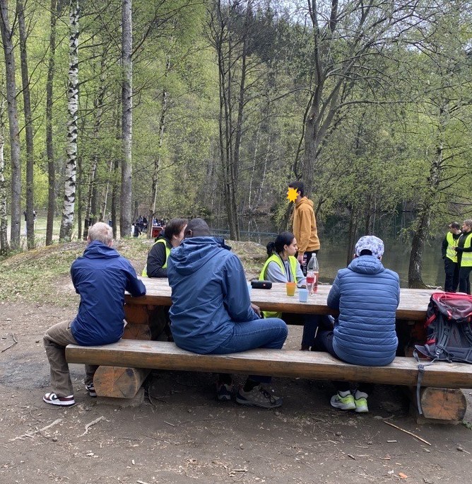 En gruppe mennesker som sitter på en benk i en park