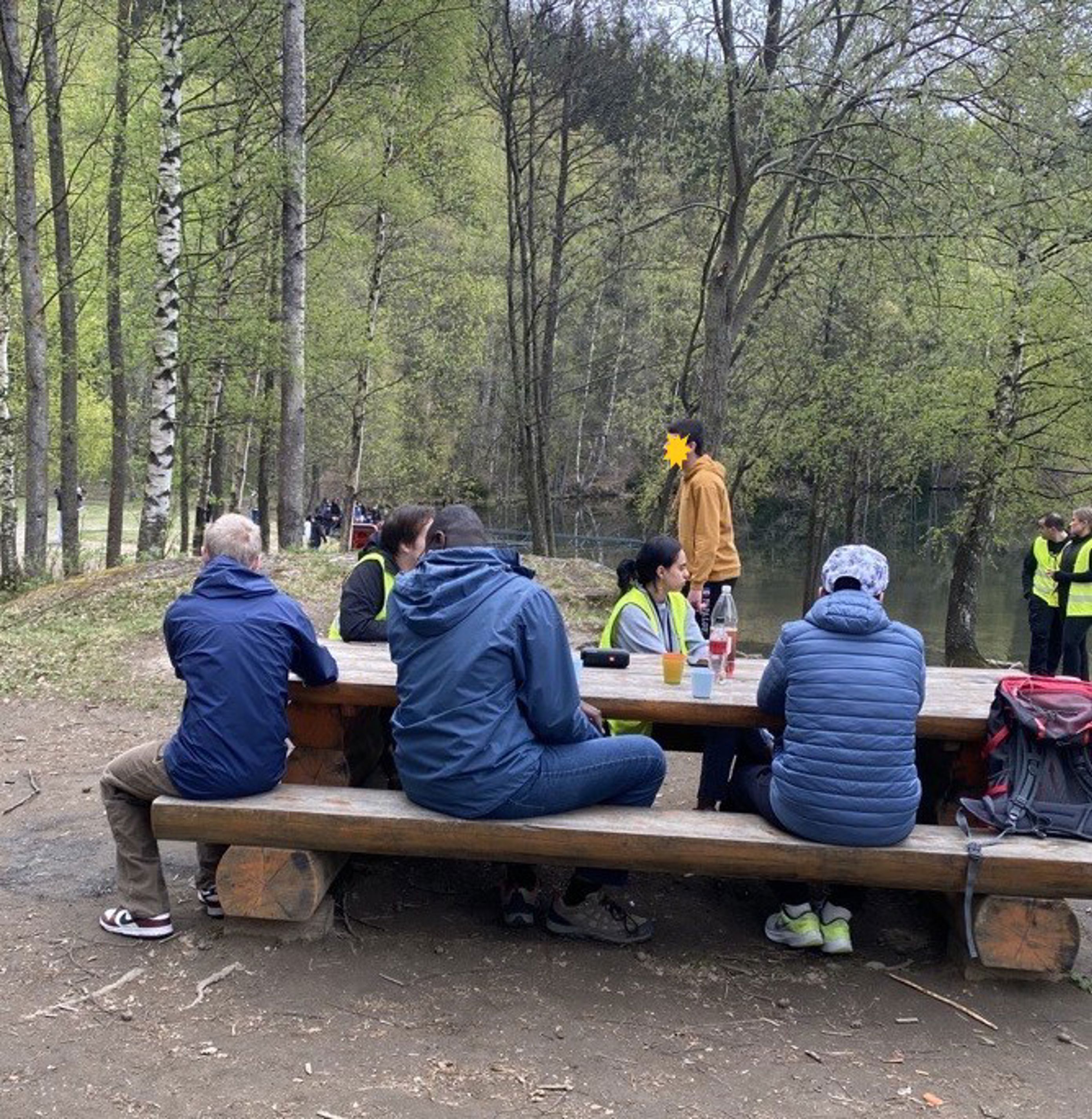 En gruppe mennesker som sitter på en benk i en park