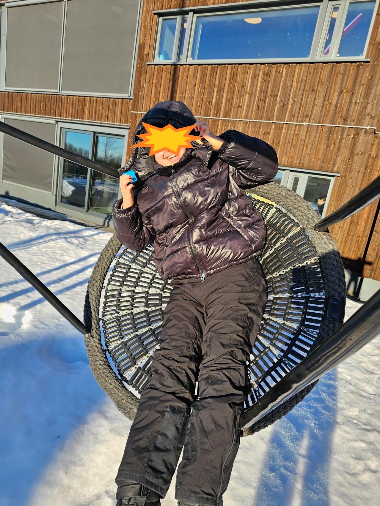 en person som har på seg en lue og holder et snowboard