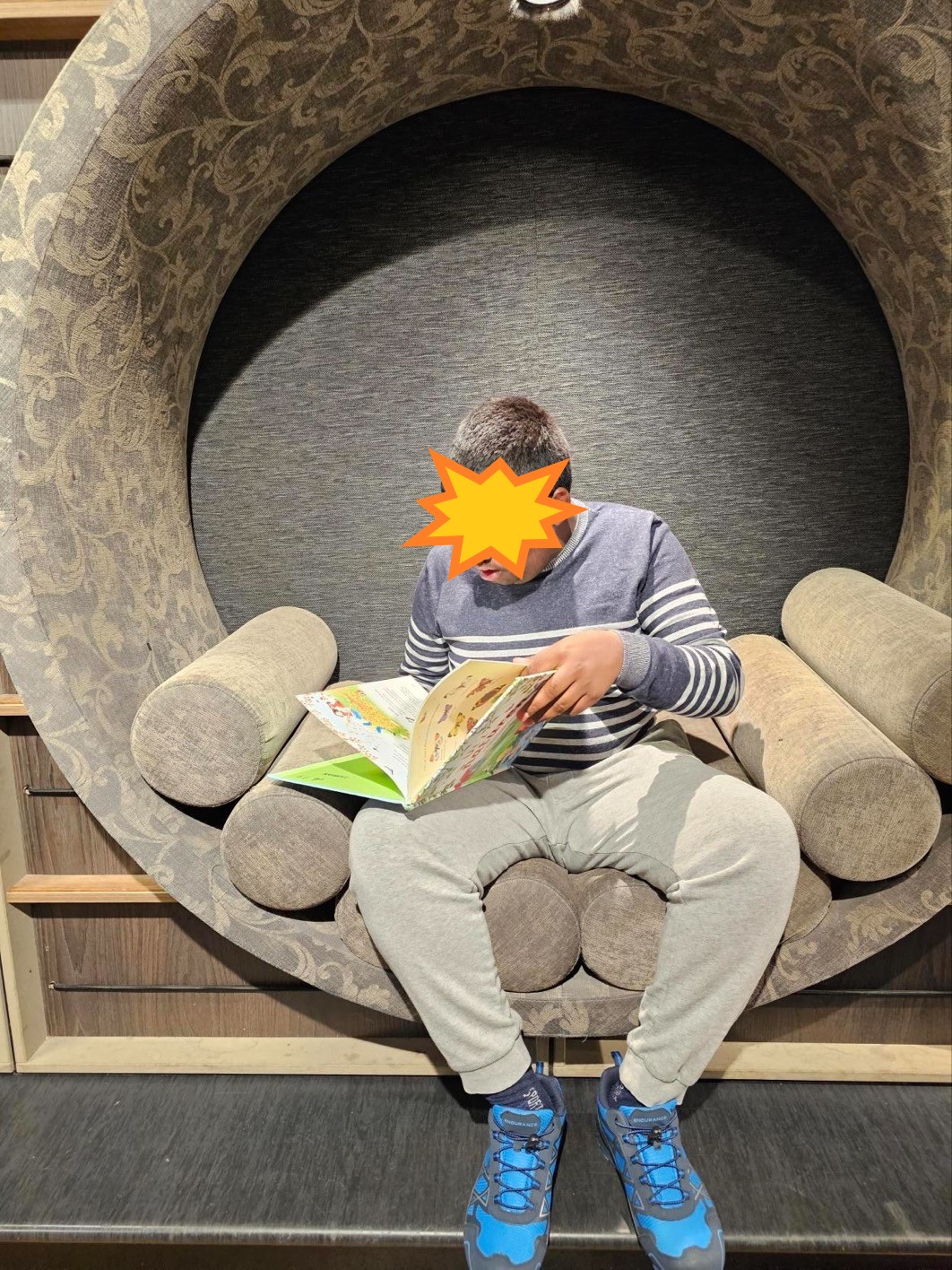 en person som sitter på en benk og leser en bok