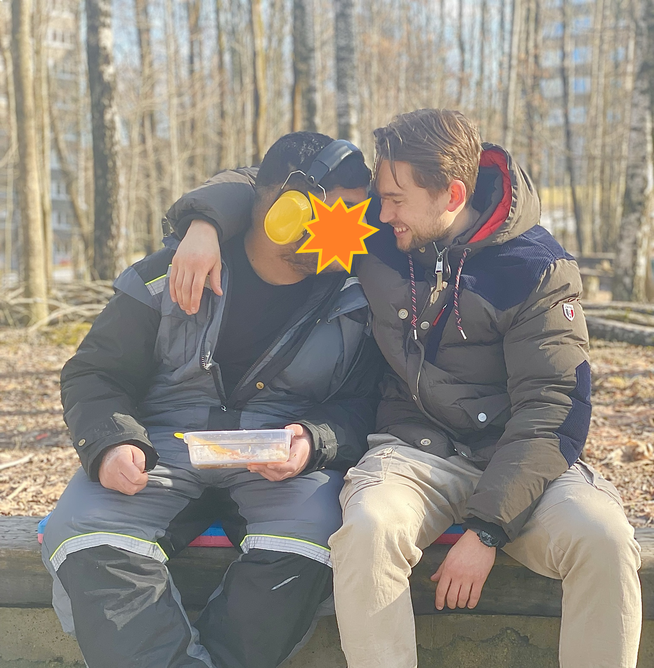 en gruppe menn som sitter på en benk i skogen