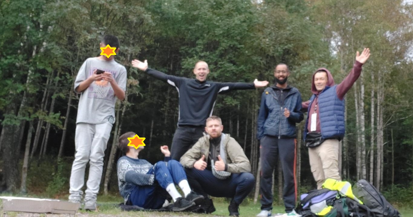 En gruppe mennesker som poserer for et bilde i skogen