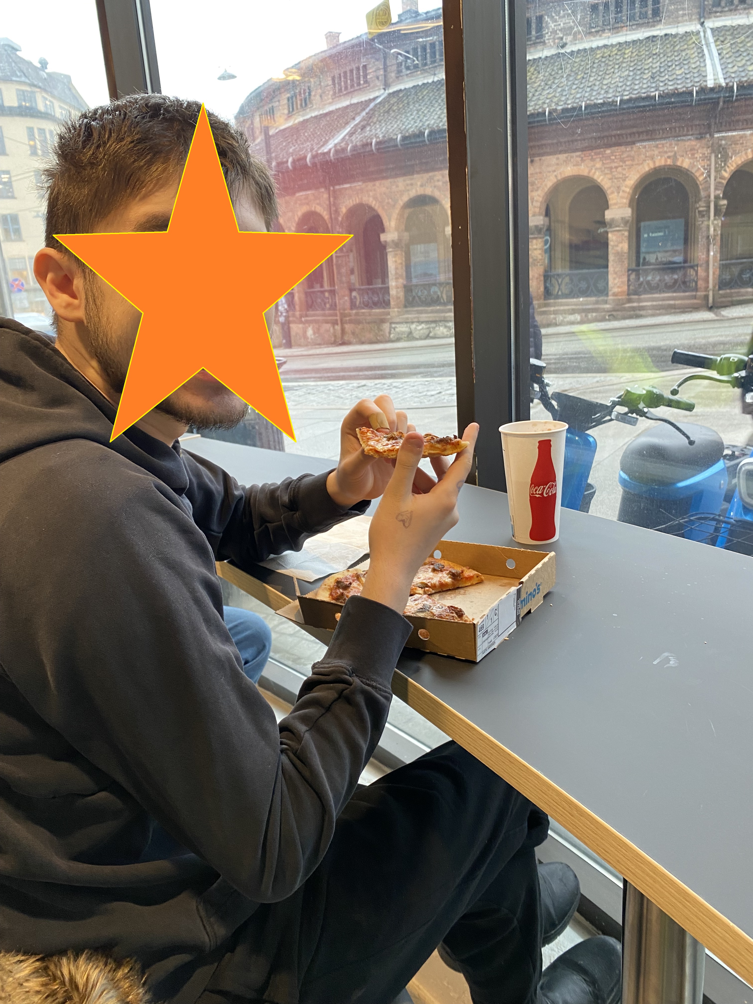 en person som spiser pizza